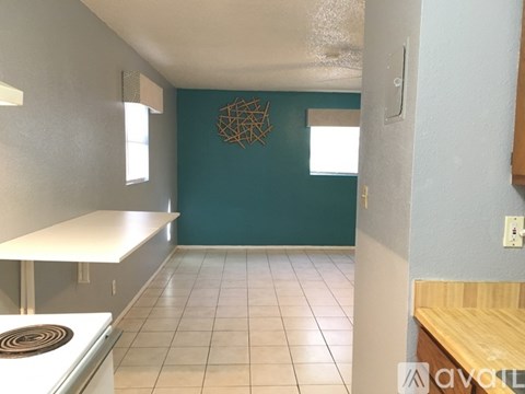 A kitchen with a white counter and a stove top oven.