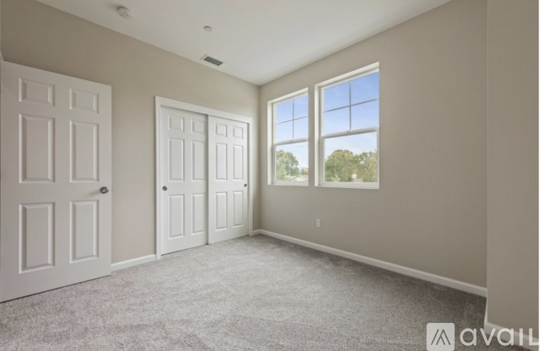 A room with two doors and a window overlooking a tree-filled landscape.