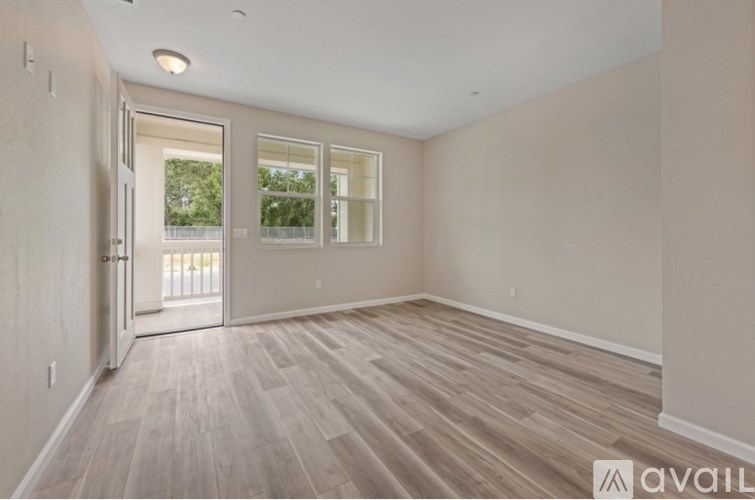 A room with wooden flooring and a door leading outside.