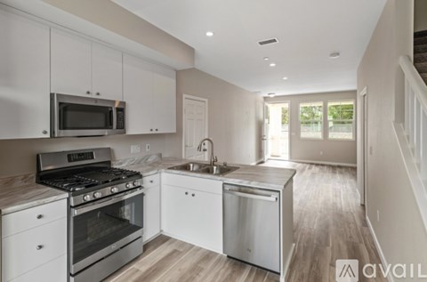 A modern kitchen with white cabinets and stainless steel appliances.