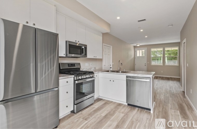 A modern kitchen with stainless steel appliances and white cabinetry.