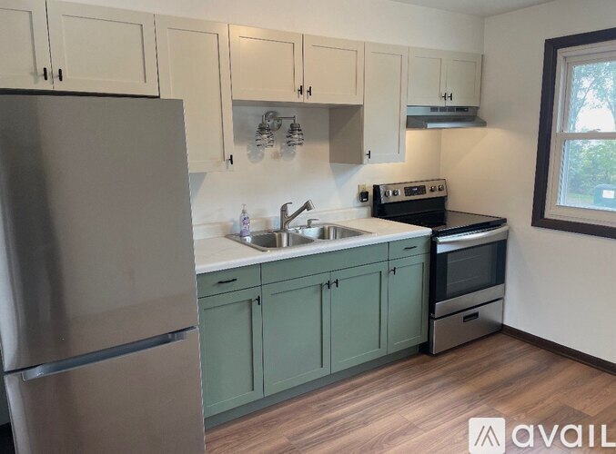 A kitchen with a refrigerator, sink, and stove.