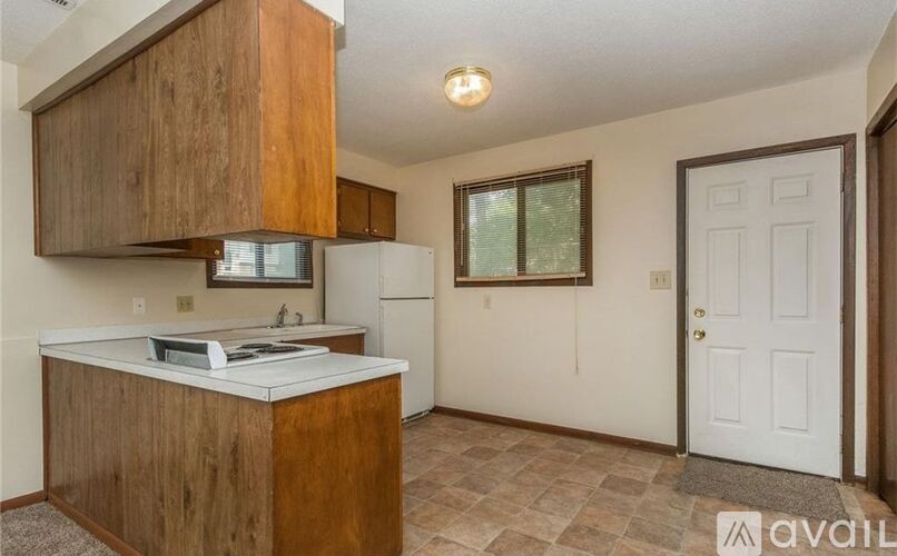 A kitchen with wooden cabinets and a white refrigerator.