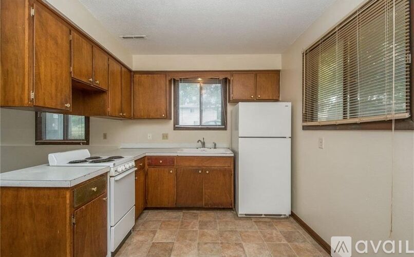 A kitchen with wooden cabinets and a white refrigerator.