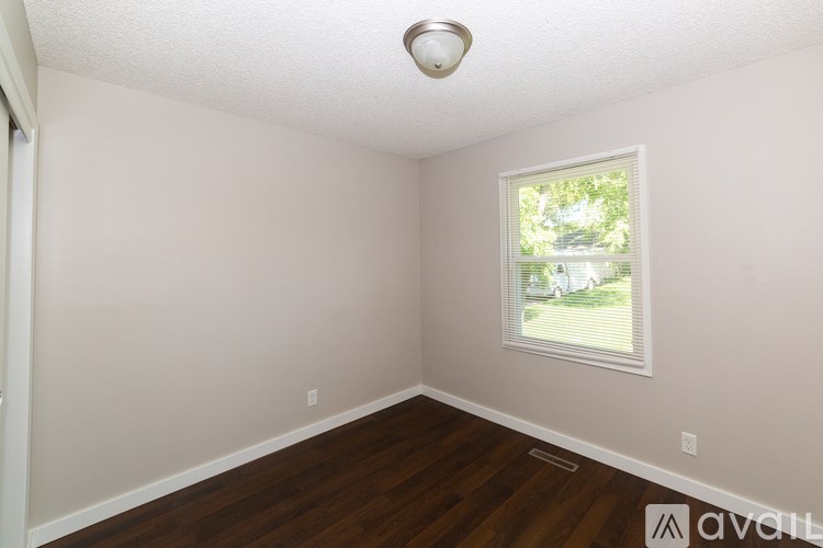 A room with a window and wooden floors.