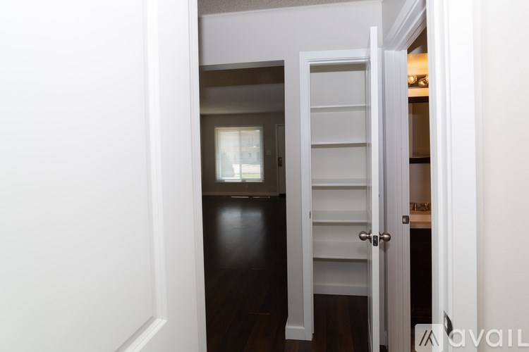 A white door is open to a dark room.