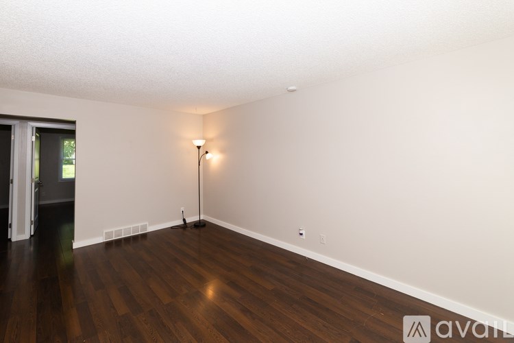 A room with wooden floors and a single light source.