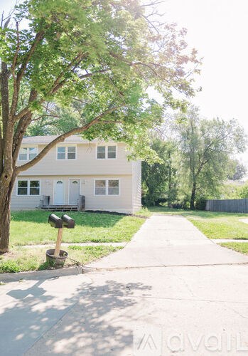 A white house with a mailbox on the sidewalk.