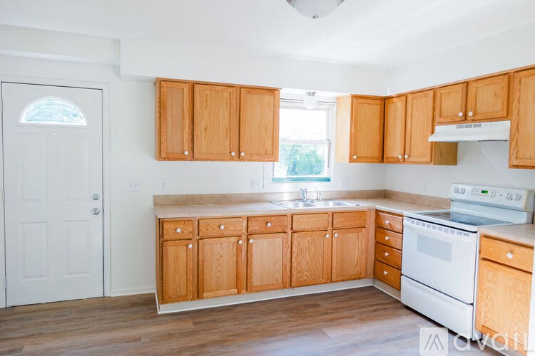 A kitchen with wooden cabinets and white appliances.