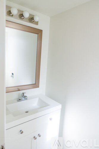 A white bathroom vanity with a sink and mirror.