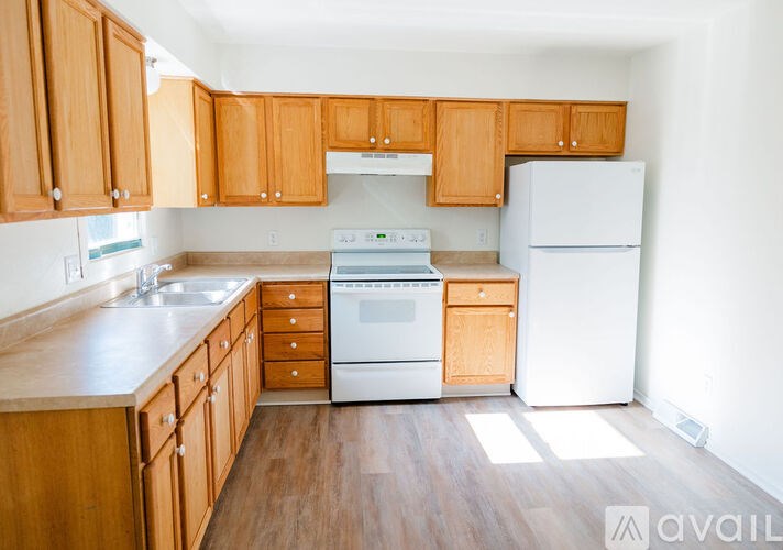 A kitchen with wooden cabinets and white appliances.
