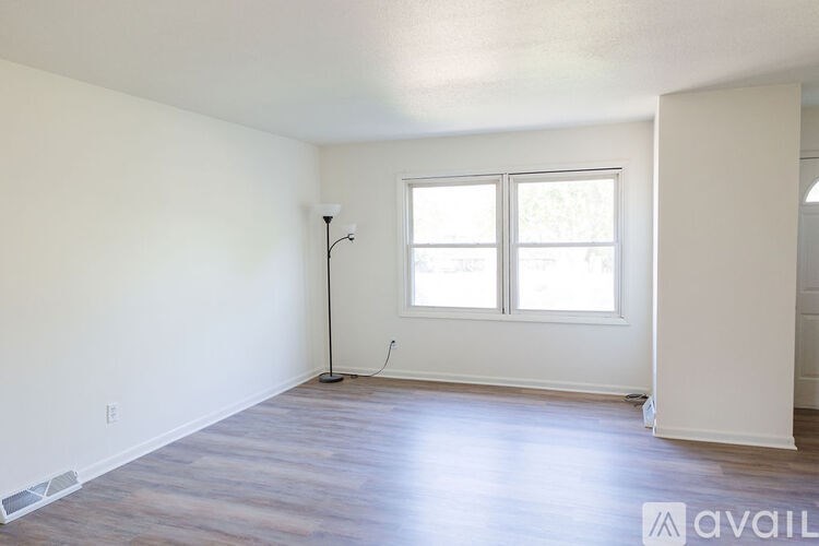 A room with a window and a floor lamp.