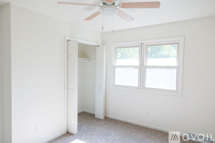A room with a ceiling fan and a window.