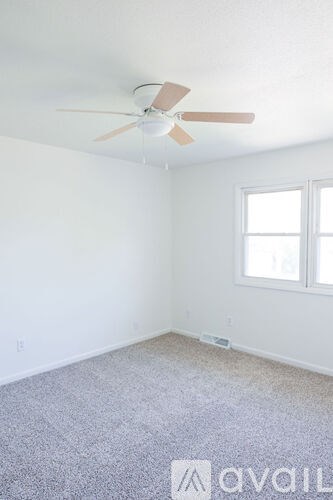 A room with a ceiling fan and a window.