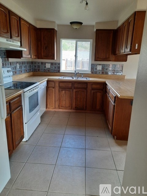A kitchen with wooden cabinets and white appliances.