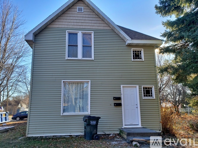 A house with a white door and a window with a curtain.