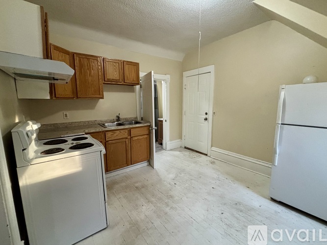 A kitchen with a white stove and a white refrigerator.