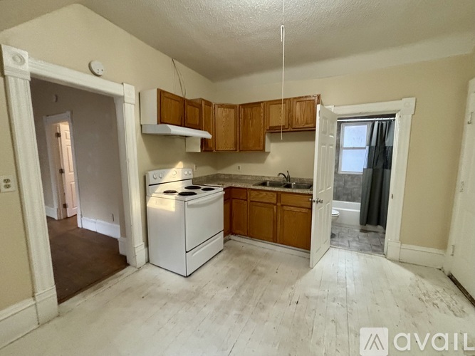 A kitchen with a white dishwasher and wooden cabinets.