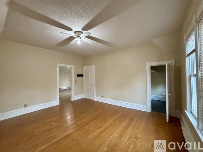 A room with wooden floors and a ceiling fan.