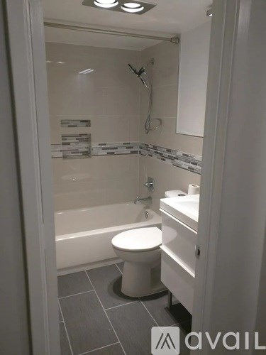 A white toilet in a small bathroom with a glass shower door.