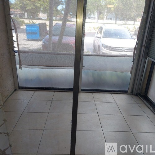 A car is parked in a parking lot outside a building.