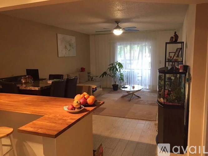 A kitchen with a wooden counter top and a bowl of fruit on it.