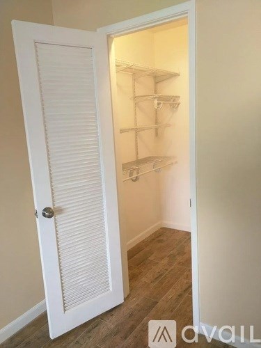 A white door with a shelving unit inside.