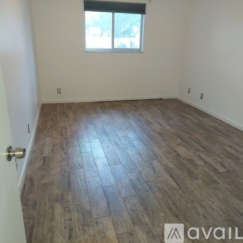 A room with wooden flooring and a window.