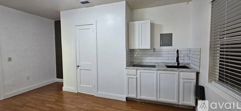 A kitchen with white cabinets and a black countertop.