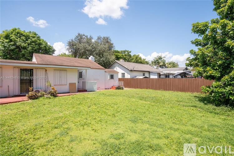 A house with a fence and a green lawn in front.