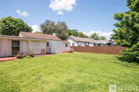 A house with a fence and a green lawn in front.