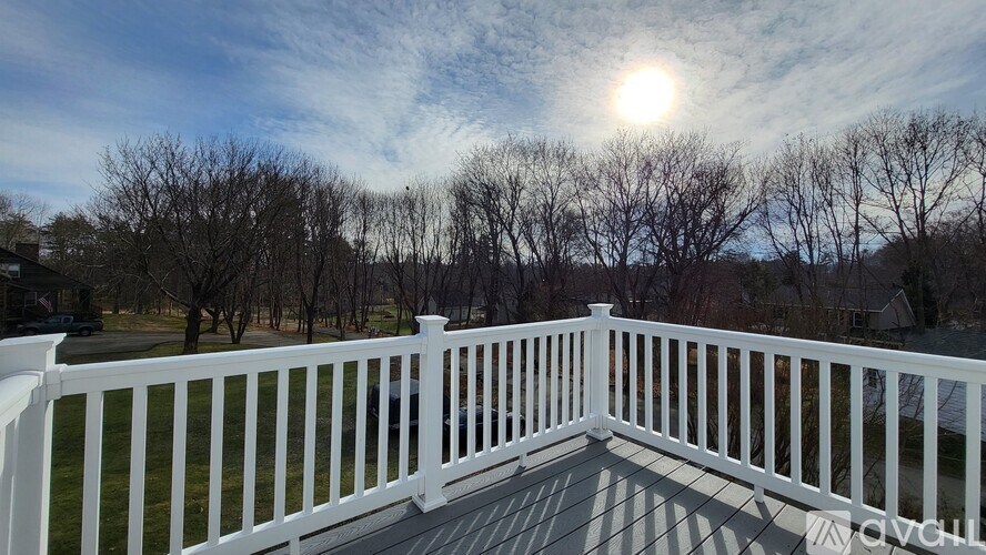 A white railing leads to a bright sunny sky.
