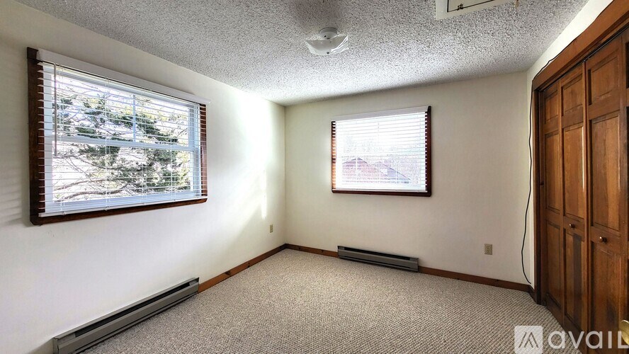 A room with a window and a door is available for rent.
