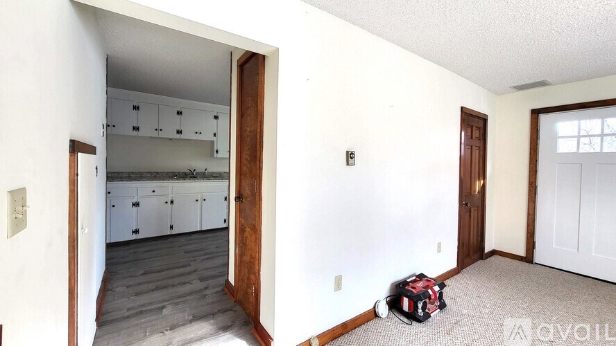 A kitchen with white cabinets and a wooden door.