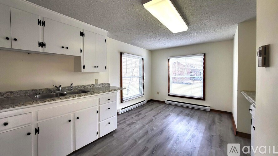 A kitchen with white cabinets and a granite countertop.