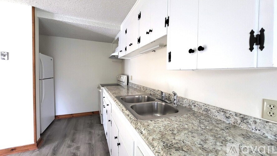A kitchen with white cabinets and a granite countertop.