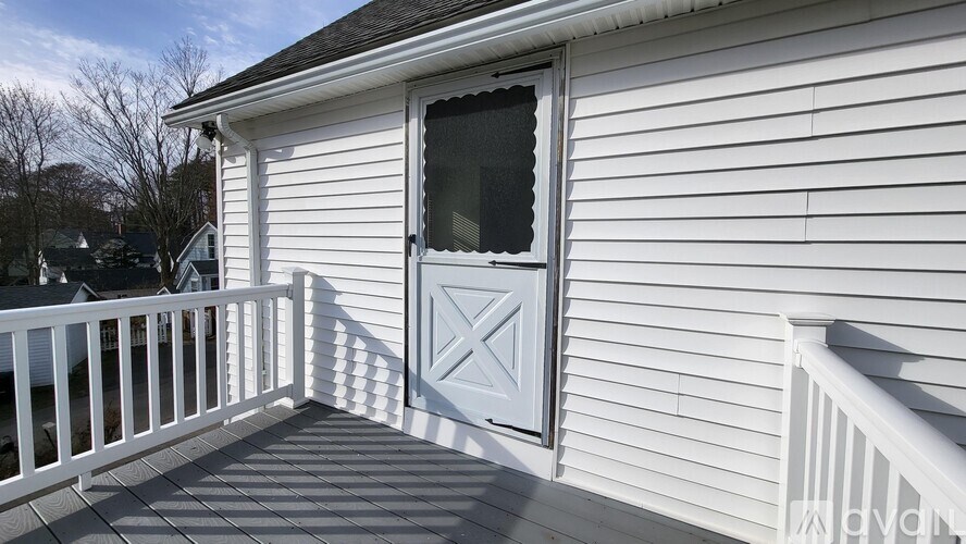 A white house with a grey door and a window.