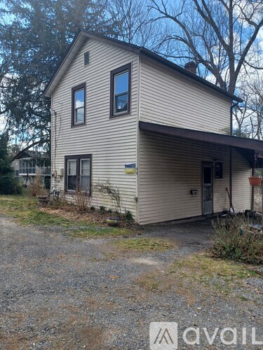A house with a gravel driveway in front.