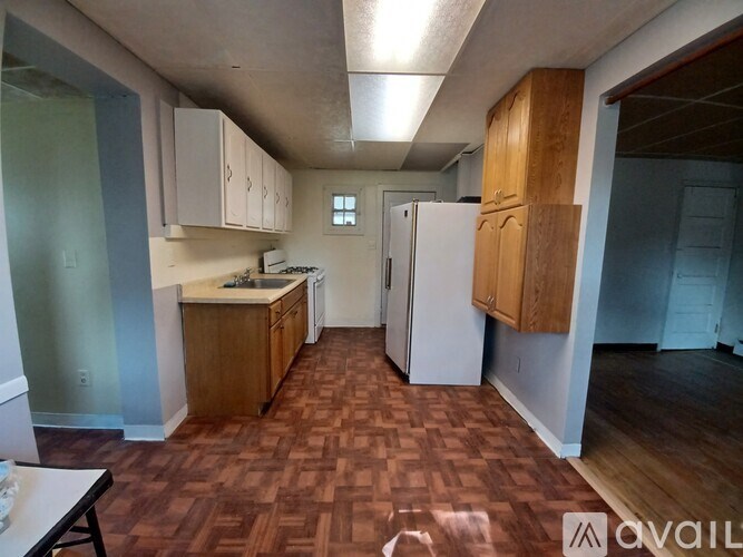 A kitchen with wooden floors and white appliances.