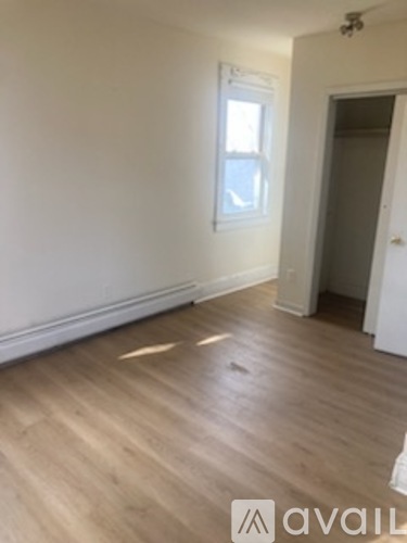A room with wooden flooring and a window.
