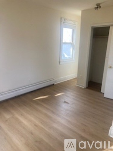 A room with wooden flooring and a window.