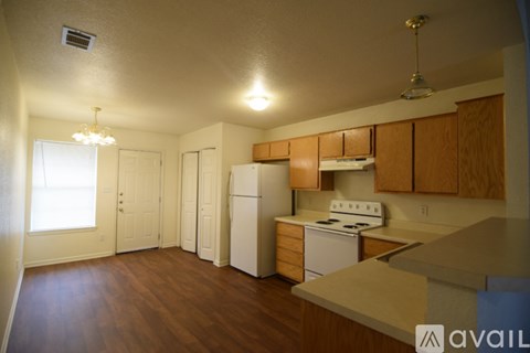 A kitchen with wooden cabinets and a white stove top oven.