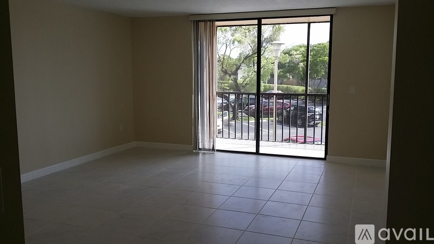 A room with a sliding glass door leading to a parking lot.