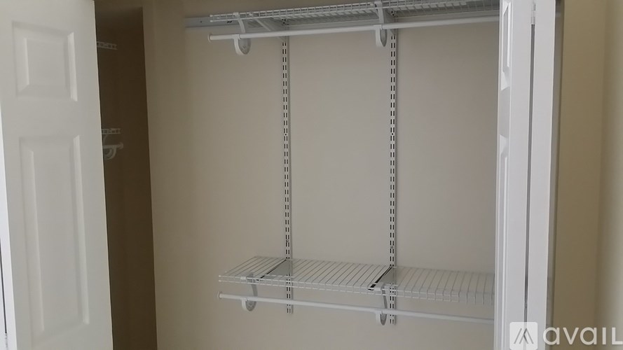 A white empty pantry with a door open.