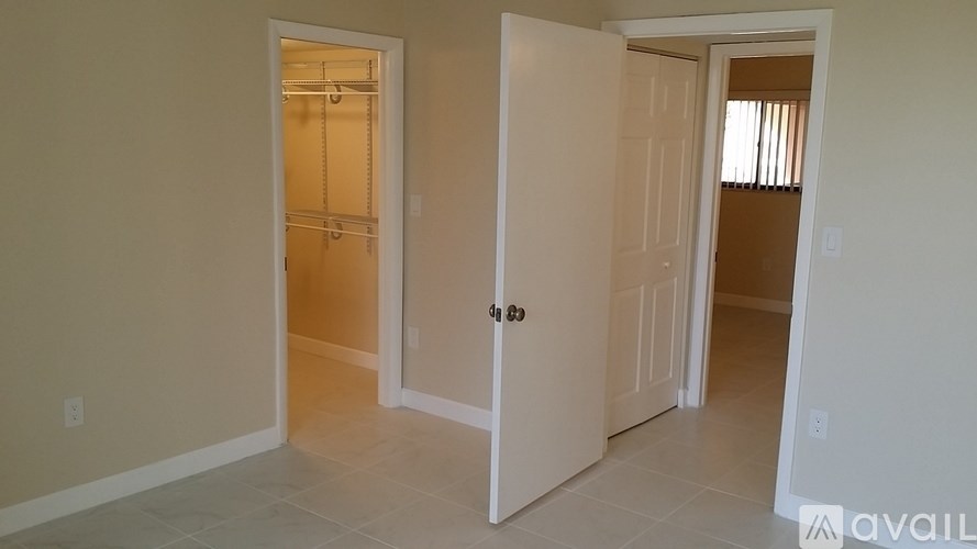 A room with two open doors and a tiled floor.