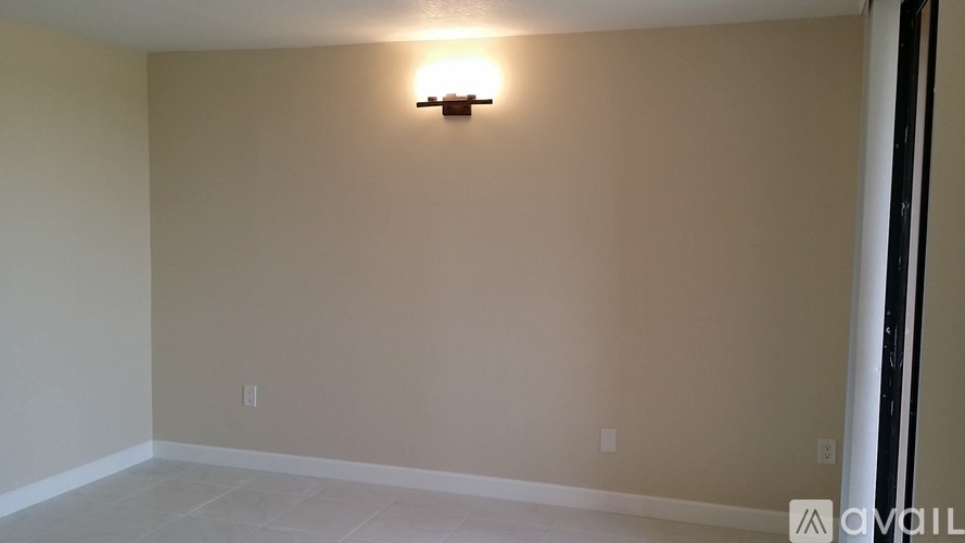 A room with a light on the wall and a floor that is tiled.