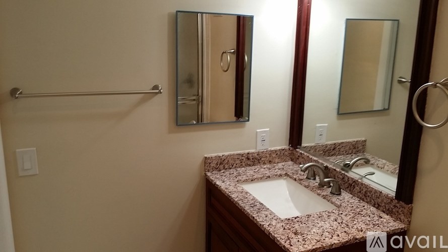A bathroom with a marble countertop and a large mirror.