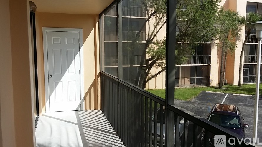 A balcony with a white door and a black railing.
