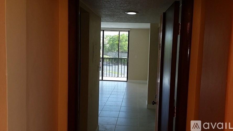 A hallway with a door leading to a balcony.