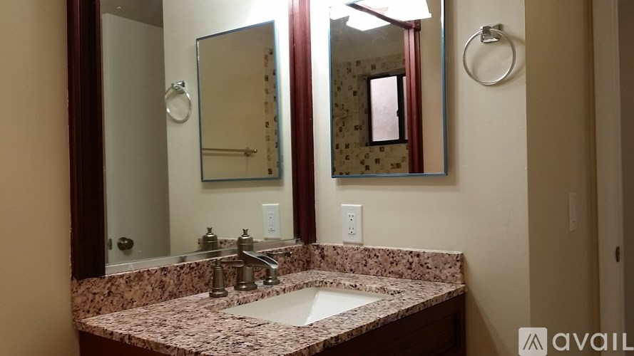 A bathroom with a marble countertop and a large mirror.
